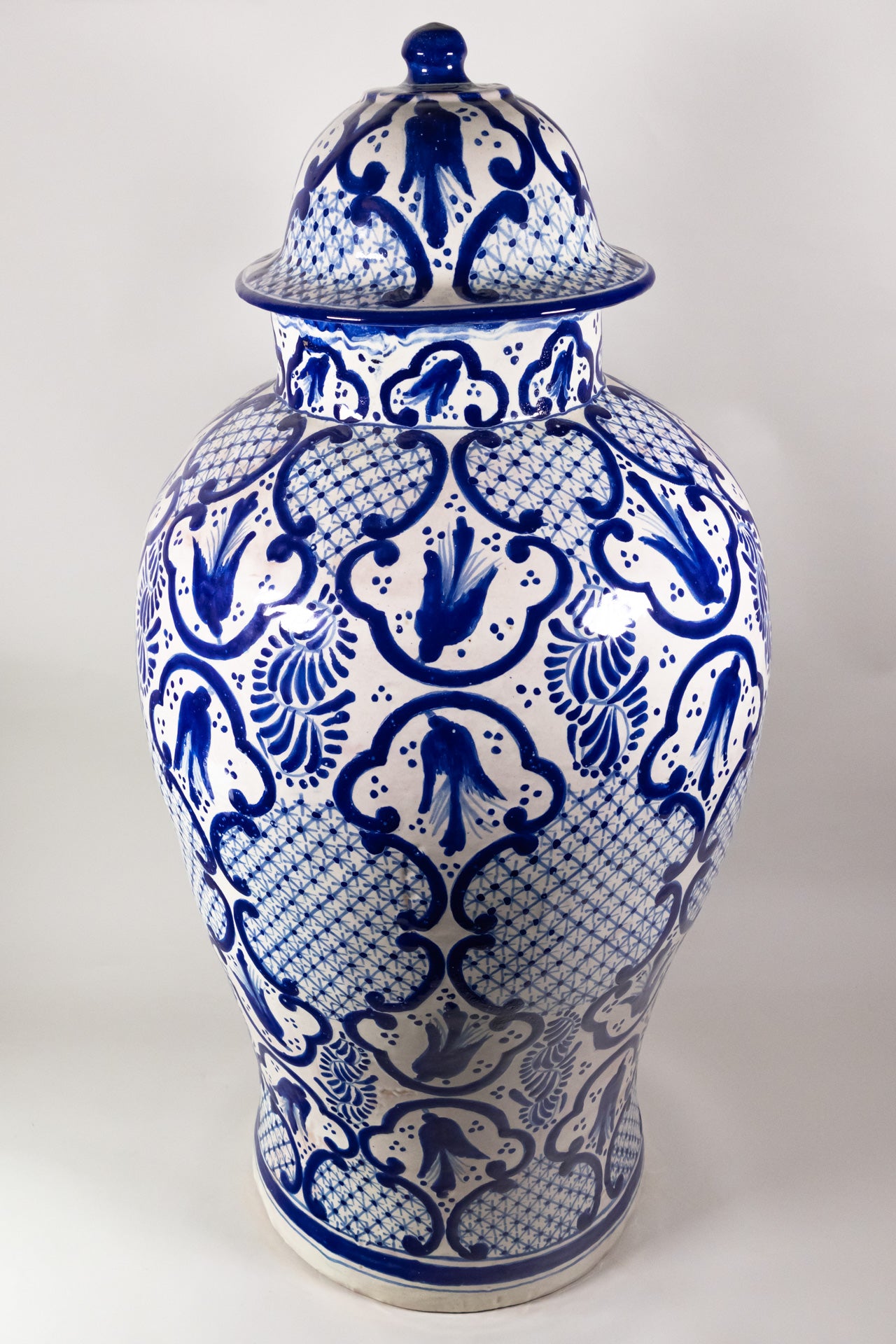 A classic cobalt blue and white talavera jar with regal artwork.