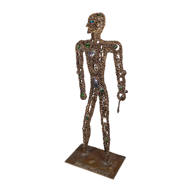 A brass metal sculpture of a hunter with gemstones and tiny figures ornate on it's body, holding a spear.