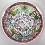 A round ceramic plate with artwork of bull fight scene in the center and spectators all around.