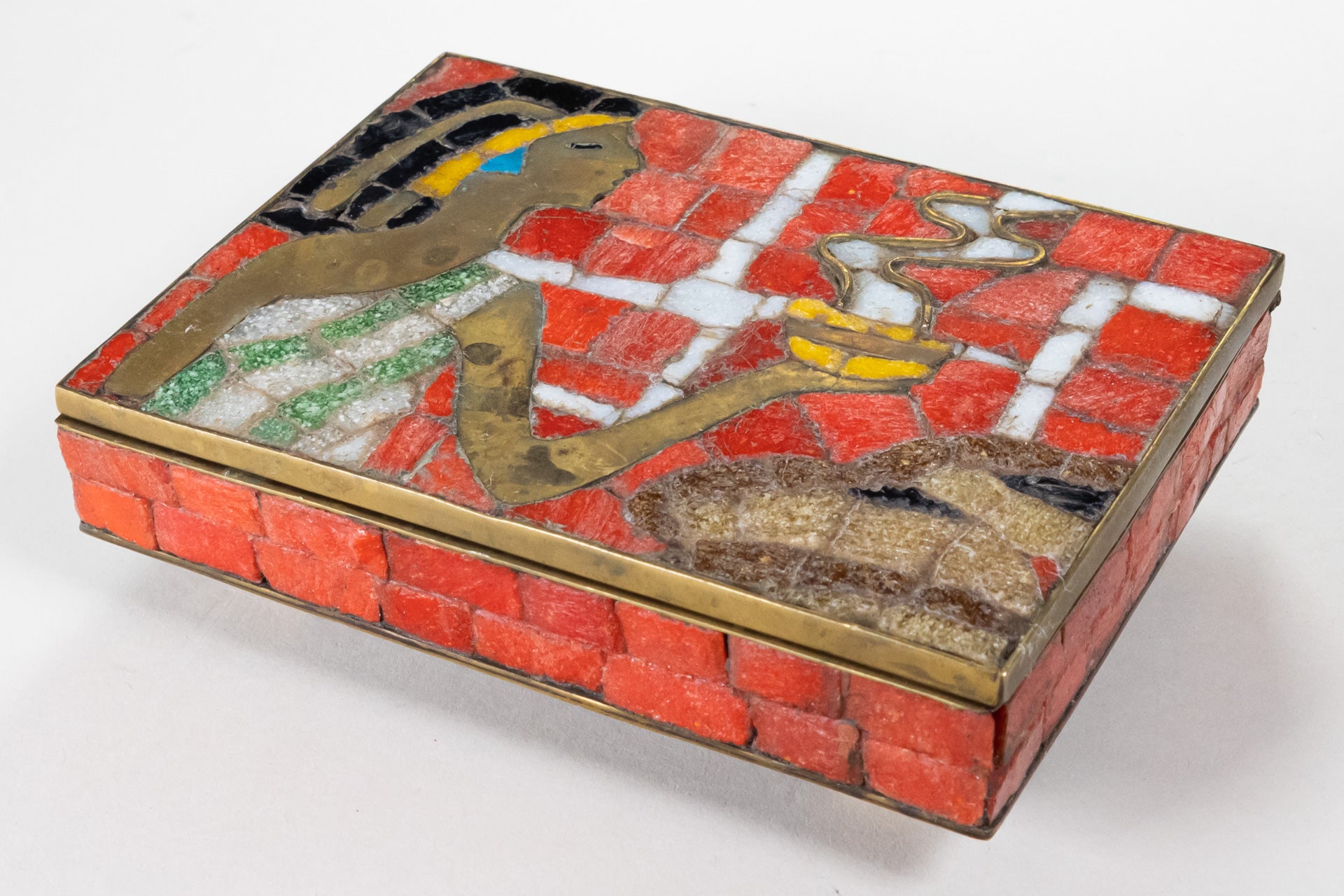 Brass box with orange glass mosaic pieces depicting an Aztec woman holding a bowl of steaming food as an offering.