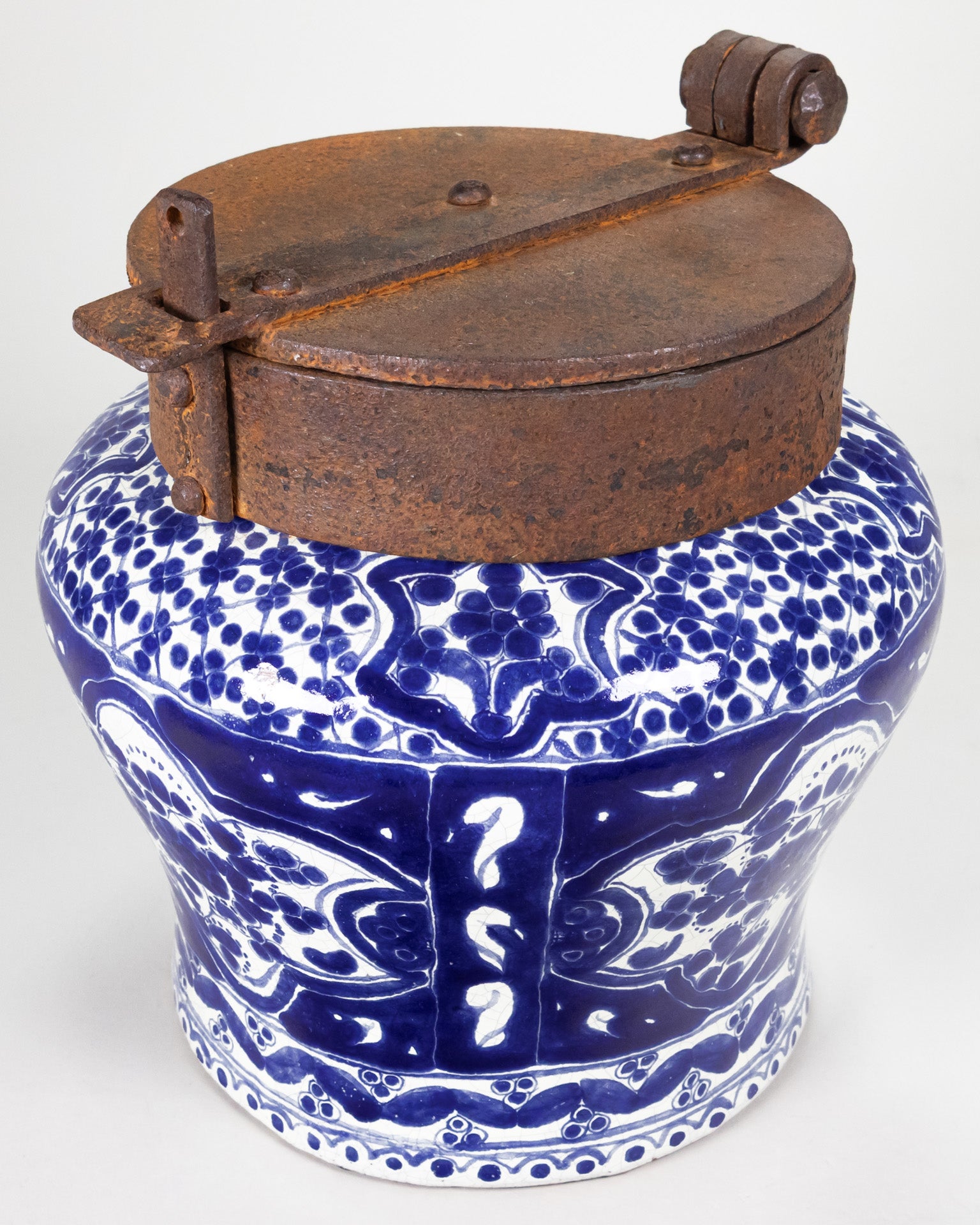 A classic cobalt blue and white talavera piece with an iron lid.