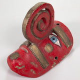 A red polychromed painted Nahua mask with a spiral nose and gold leaf painted details.