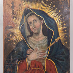 Retablo painting of the Virgin Mary, grieving as tears fall from her eyes, hands clasp with a dagger piercing her heart.