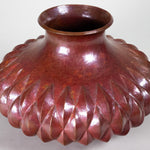 Copper vase with a diamond pattern and inverted top rim.