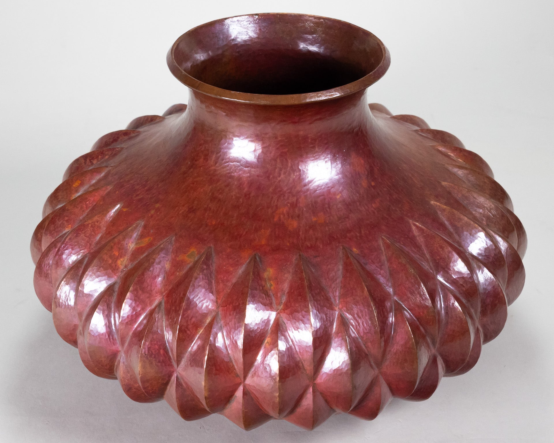 Copper vase with a diamond pattern and inverted top rim.