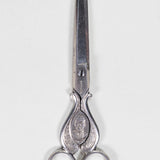 Silver sewing scissors decorated with a plant and floral design, with President Porfirio Diaz's bust.