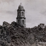 Black and white postcard of the Church of San Juan Parangaricutiro surrounded by the ash from the aftermath of  the eruption of Parícutin.