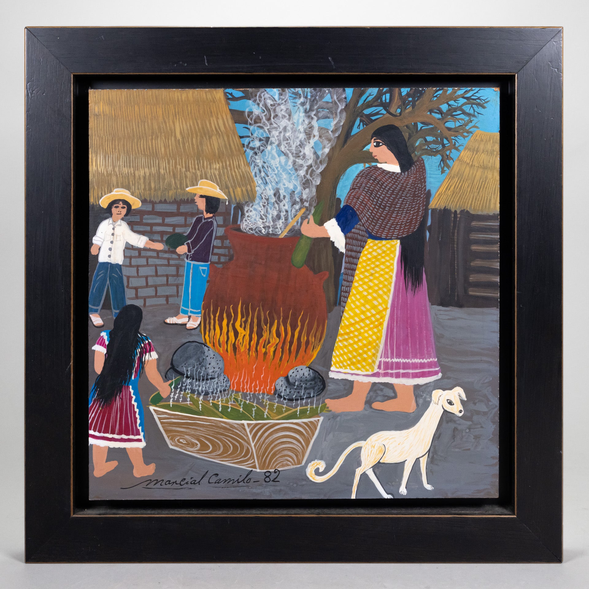 Framed oil on wood painting of an outdoor village scene, with stone buildings in the background, a woman cooking with an open fire, children in the background and a white dog in the foreground.